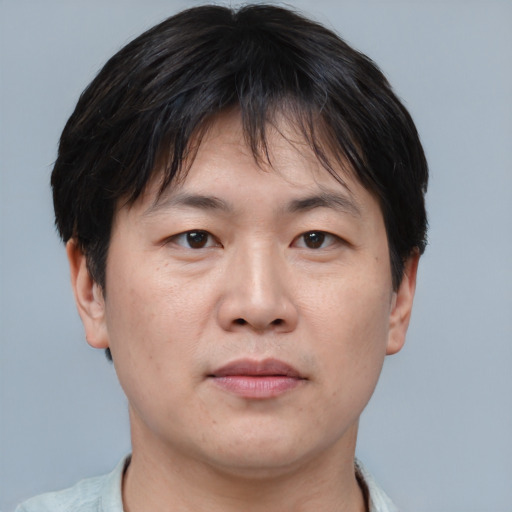 Joyful asian adult male with short  brown hair and brown eyes