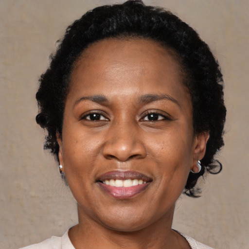 Joyful black adult female with short  black hair and brown eyes