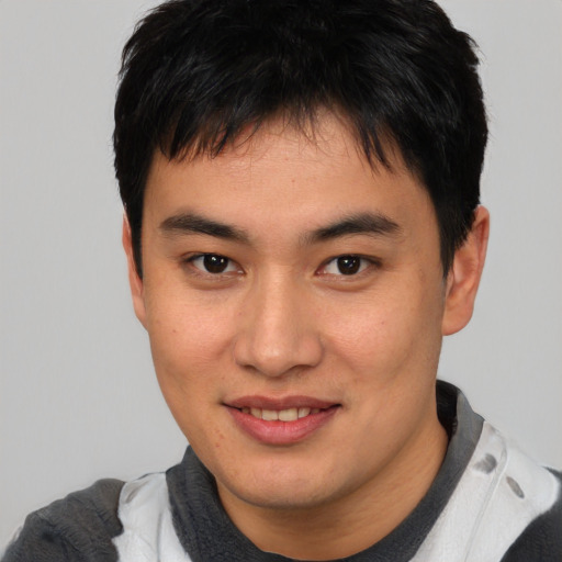 Joyful asian young-adult male with short  brown hair and brown eyes
