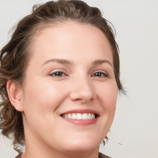 Joyful white young-adult female with medium  brown hair and blue eyes