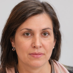 Joyful white adult female with long  brown hair and brown eyes