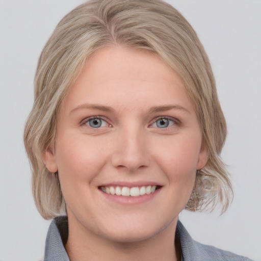 Joyful white young-adult female with medium  blond hair and blue eyes