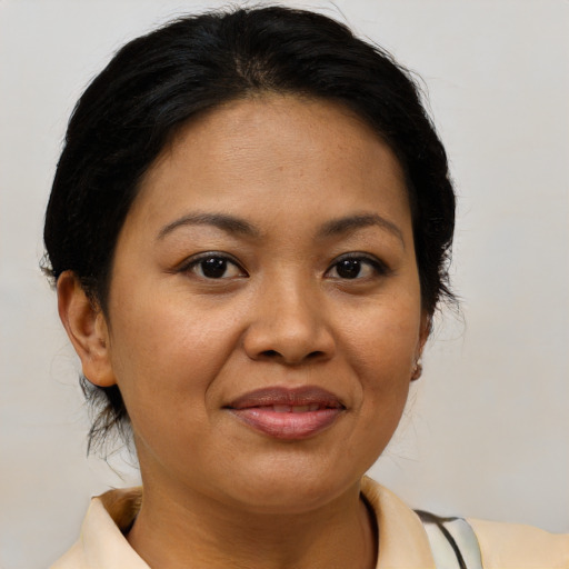 Joyful asian adult female with medium  brown hair and brown eyes