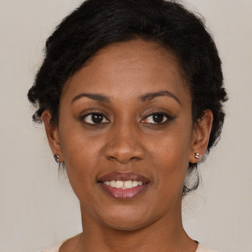 Joyful black young-adult female with short  black hair and brown eyes