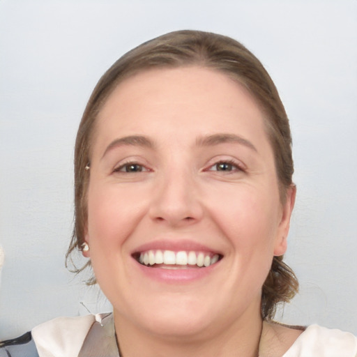 Joyful white young-adult female with medium  brown hair and grey eyes