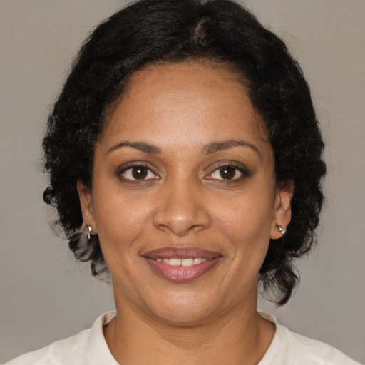 Joyful black adult female with medium  brown hair and brown eyes