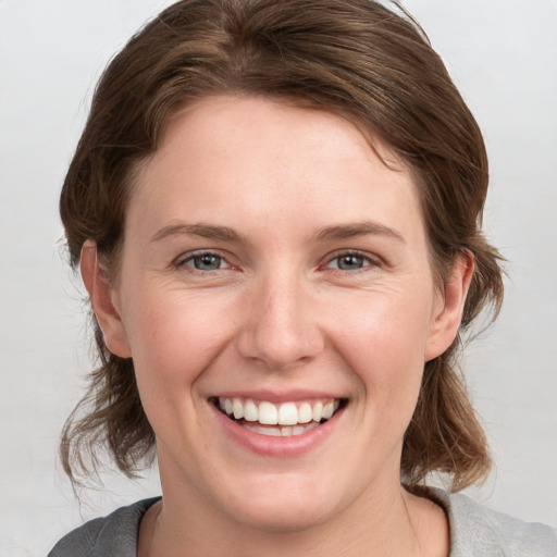 Joyful white young-adult female with medium  brown hair and blue eyes