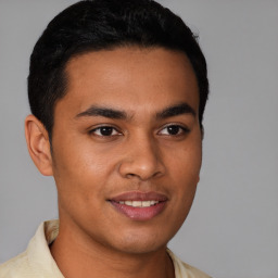 Joyful latino young-adult male with short  brown hair and brown eyes