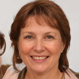 Joyful white adult female with medium  brown hair and blue eyes