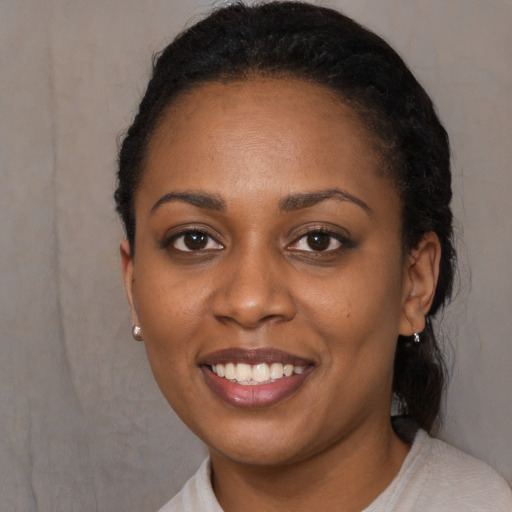 Joyful black young-adult female with short  black hair and brown eyes
