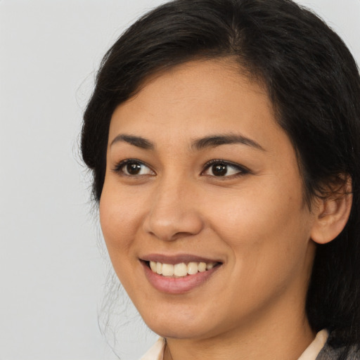 Joyful latino young-adult female with medium  brown hair and brown eyes