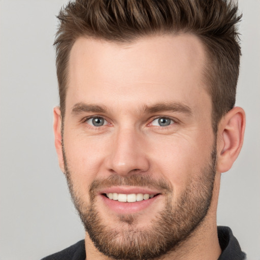 Joyful white adult male with short  brown hair and grey eyes