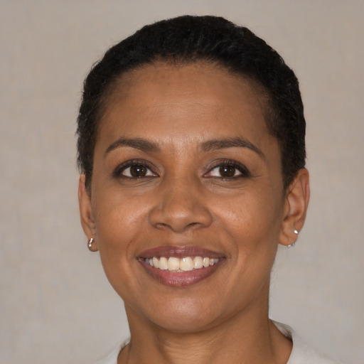 Joyful black adult female with short  black hair and brown eyes