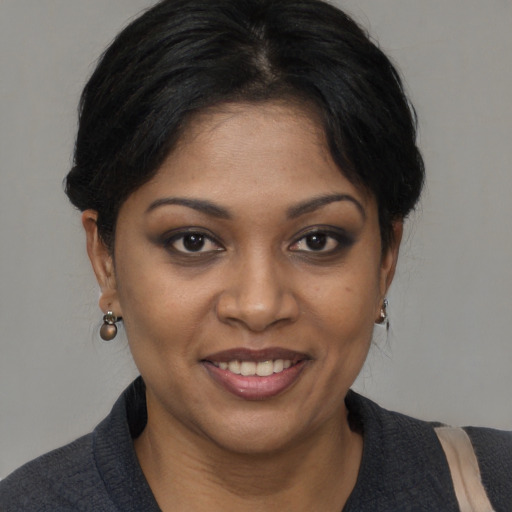 Joyful black young-adult female with medium  brown hair and brown eyes