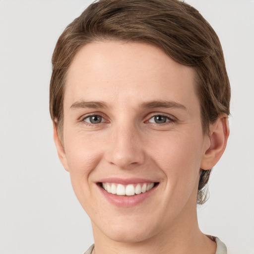 Joyful white young-adult female with short  brown hair and grey eyes