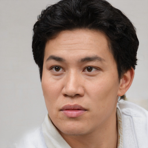 Joyful asian adult male with short  brown hair and brown eyes