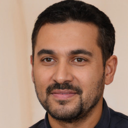 Joyful latino young-adult male with short  black hair and brown eyes