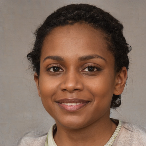 Joyful black young-adult female with short  brown hair and brown eyes