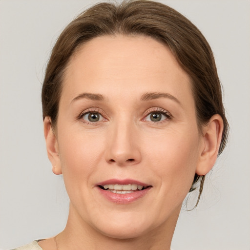 Joyful white adult female with medium  brown hair and grey eyes