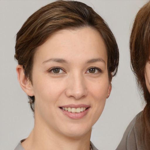 Joyful white young-adult female with medium  brown hair and brown eyes