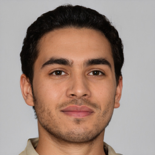 Joyful latino young-adult male with short  brown hair and brown eyes