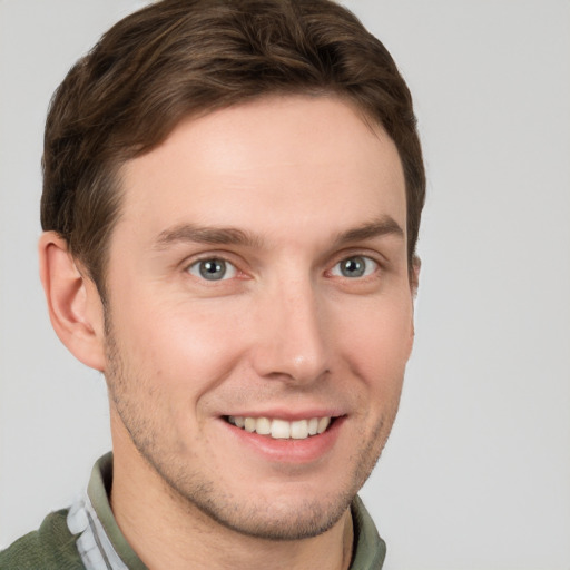 Joyful white young-adult male with short  brown hair and grey eyes