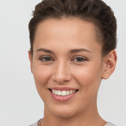 Joyful white young-adult female with short  brown hair and brown eyes