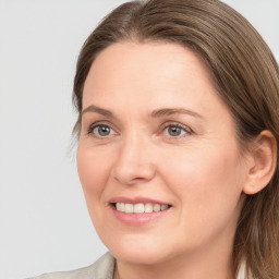 Joyful white adult female with long  brown hair and grey eyes