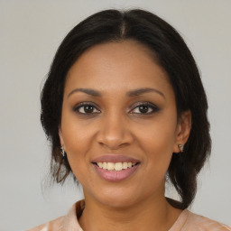 Joyful black young-adult female with medium  brown hair and brown eyes