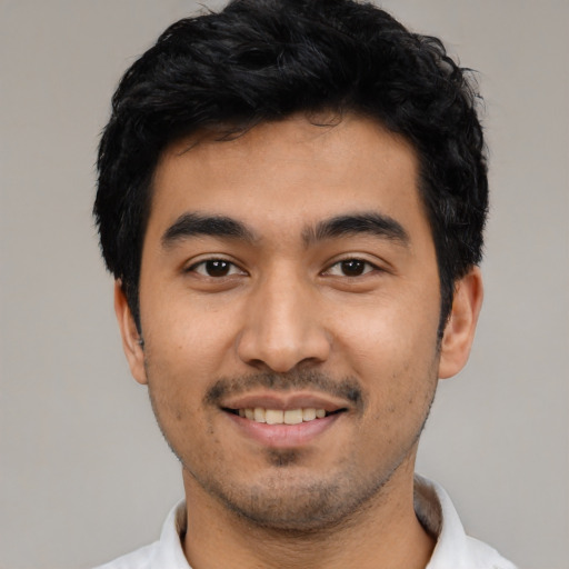 Joyful latino young-adult male with short  black hair and brown eyes