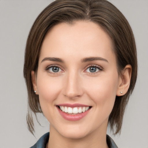 Joyful white young-adult female with medium  brown hair and grey eyes