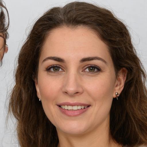 Joyful white young-adult female with long  brown hair and brown eyes