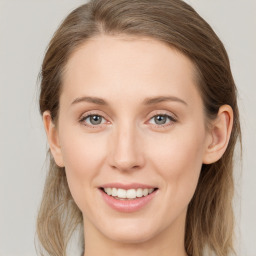 Joyful white young-adult female with long  brown hair and blue eyes