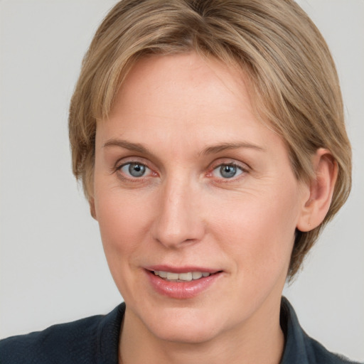 Joyful white adult female with medium  brown hair and grey eyes