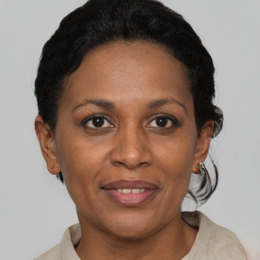 Joyful black adult female with short  brown hair and brown eyes