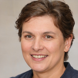 Joyful white adult female with medium  brown hair and grey eyes