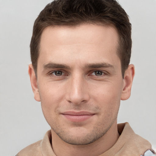 Joyful white young-adult male with short  brown hair and grey eyes