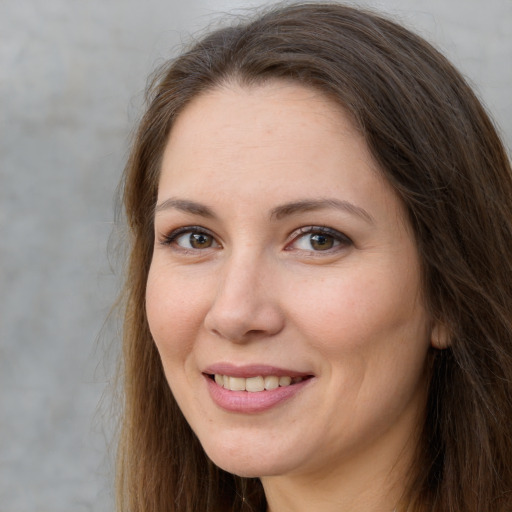 Joyful white adult female with long  brown hair and brown eyes