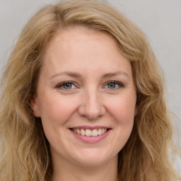 Joyful white young-adult female with long  brown hair and green eyes