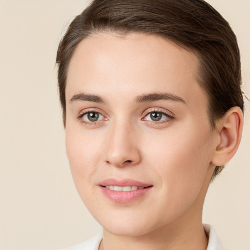 Joyful white young-adult female with short  brown hair and green eyes