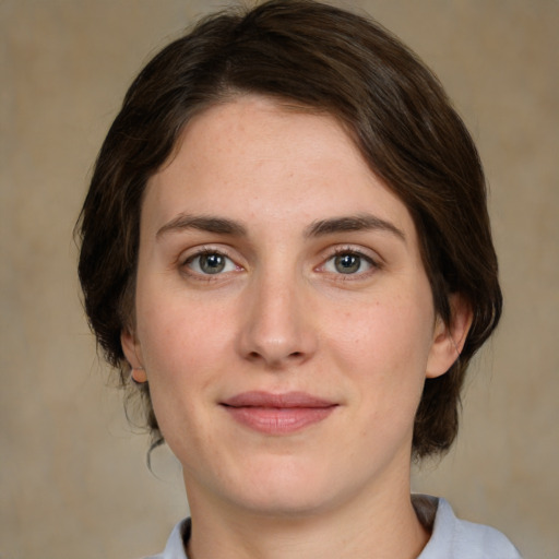 Joyful white young-adult female with medium  brown hair and green eyes