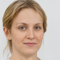 Joyful white young-adult female with medium  brown hair and green eyes