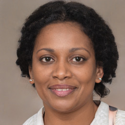 Joyful black adult female with medium  brown hair and brown eyes