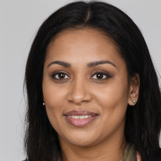 Joyful black young-adult female with long  brown hair and brown eyes