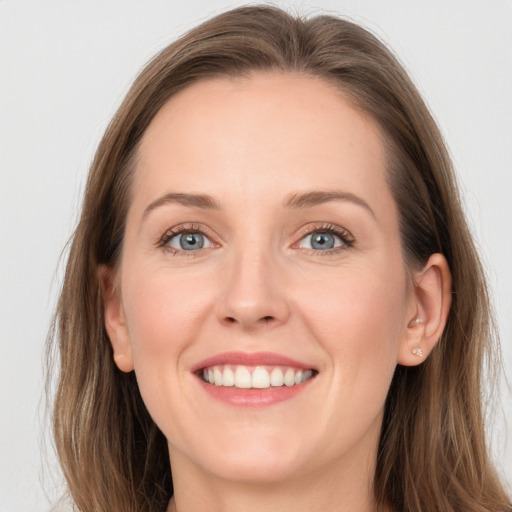 Joyful white young-adult female with long  brown hair and blue eyes