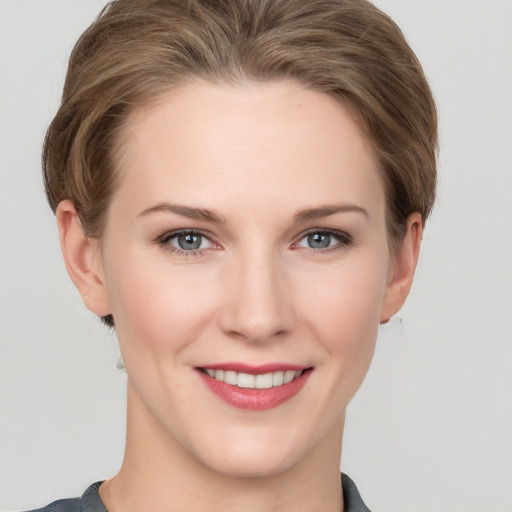 Joyful white young-adult female with short  brown hair and grey eyes