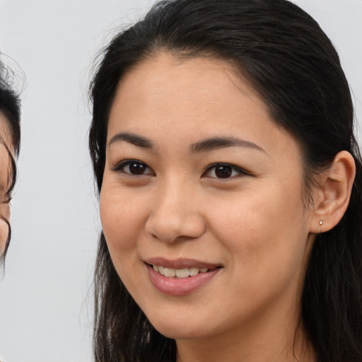 Joyful asian young-adult female with long  brown hair and brown eyes