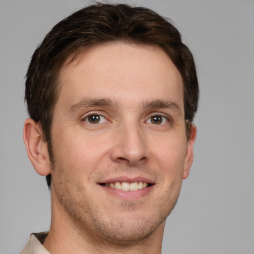 Joyful white young-adult male with short  brown hair and grey eyes