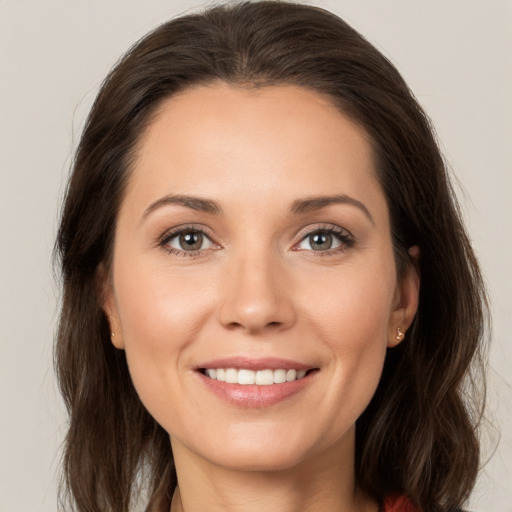 Joyful white young-adult female with long  brown hair and brown eyes