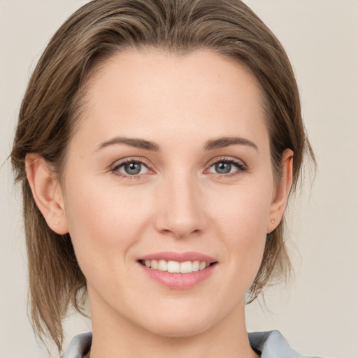 Joyful white young-adult female with medium  brown hair and grey eyes